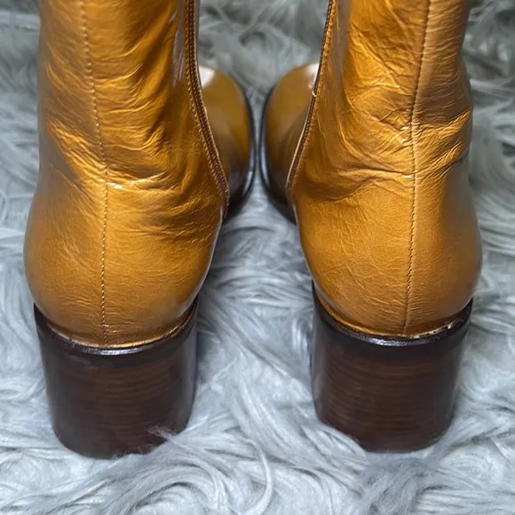 Intentionally blank patent leather heeled boots