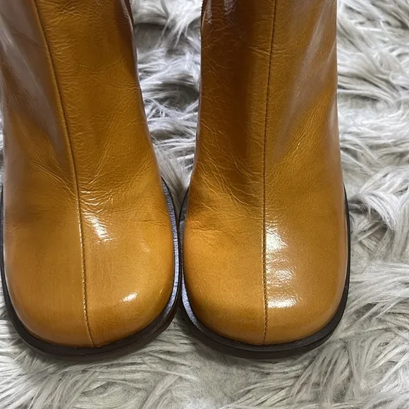 Intentionally blank patent leather heeled boots