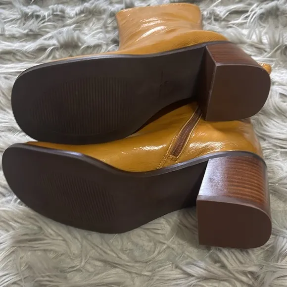 Intentionally blank patent leather heeled boots