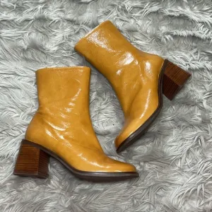 Intentionally blank patent leather heeled boots