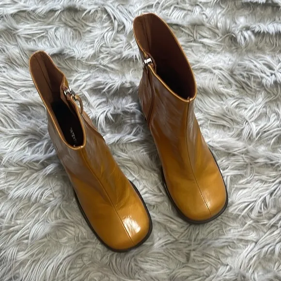 Intentionally blank patent leather heeled boots