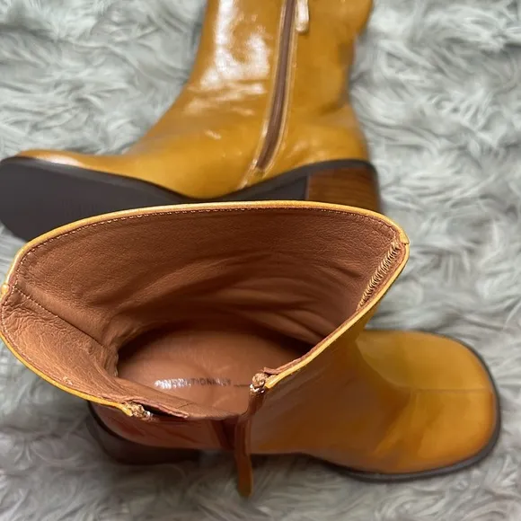 Intentionally blank patent leather heeled boots