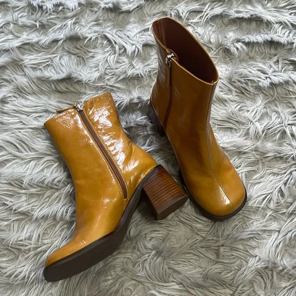 Intentionally blank patent leather heeled boots